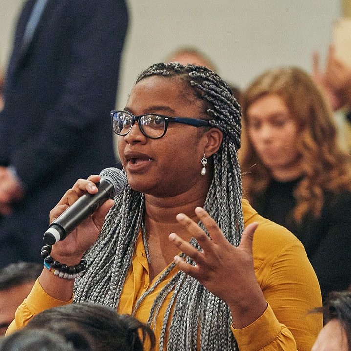 Public diplomacy student speaking into a microphone in a forum